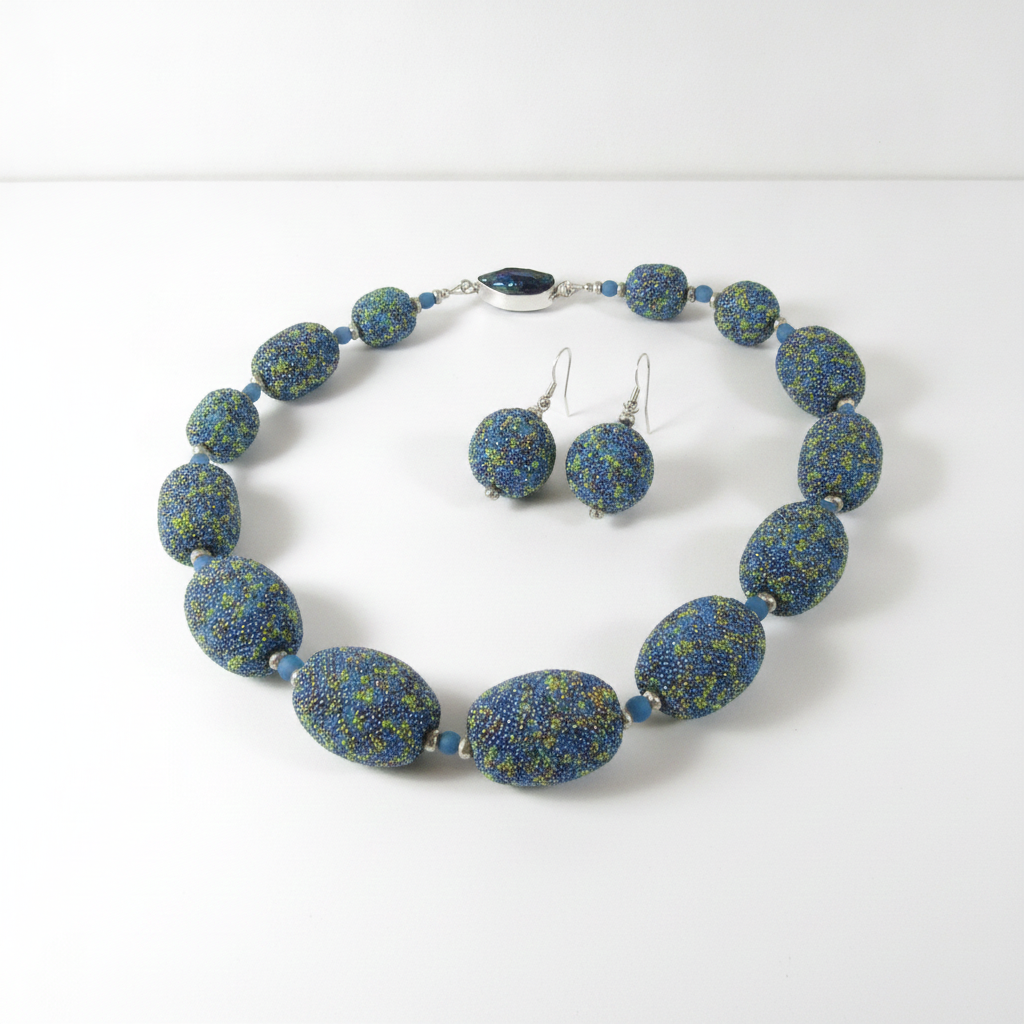 Blue and gold speckled necklace and earrings on a white background