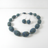 Blue and gold speckled necklace and earrings on a white background