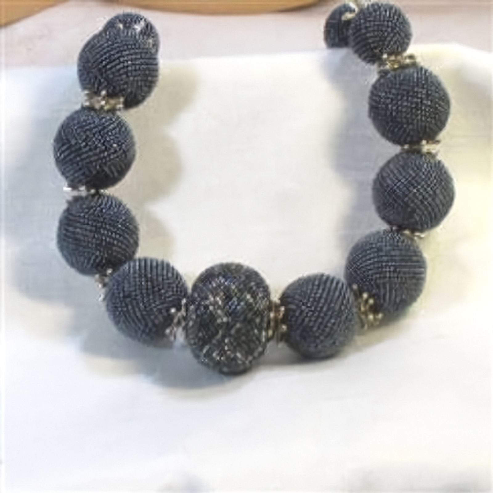 Necklace with dark blue beaded design on a light background