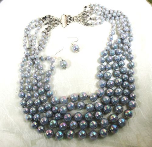 Multi-strand pearl necklace with matching earrings on a white background